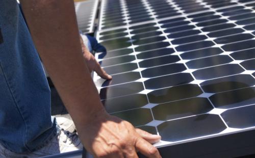 Minnesota worker installs solar panel MnSEIA